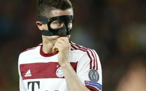 Piłkarz w masce ochronnej na twarzy, być może zastanawia się, dlaczego Lewandowski gra w masce.
