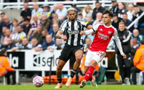 Piłkarze Newcastle i Arsenal walczą o piłkę na boisku. Intensywna akcja podczas meczu.
