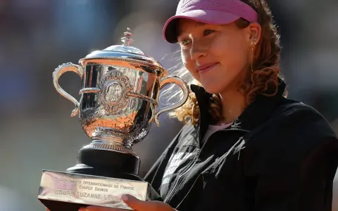Uśmiechnięta tenisistka z pucharem Suzanne Lenglen po zwycięstwie w finale Roland Garros.