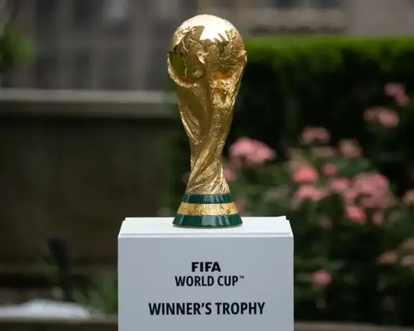 Złote trofeum FIFA World Cup na białym postumencie, symbol marzeń o zwycięstwie na **mistrzostwach świata 2030**.