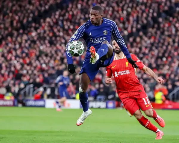 Piłkarz PSG w powietrzu z piłką, obok zawodnik Liverpoolu. Emocjonujący mecz PSG – Liverpool.