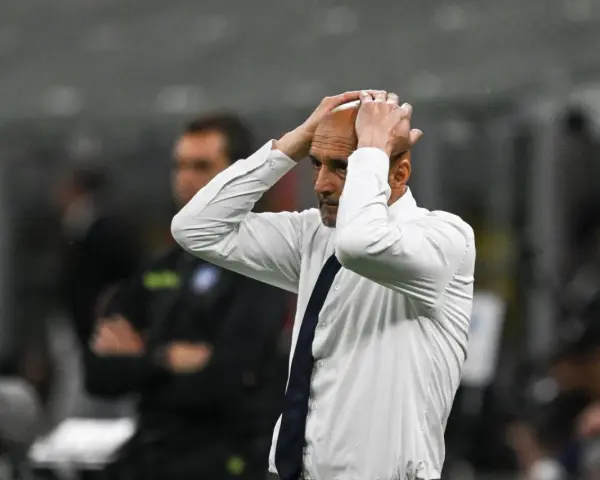 Trener w białej koszuli z granatowym krawatem, z rękami na głowie, przeżywa trudne chwile podczas meczu Juventus AC Milan.
