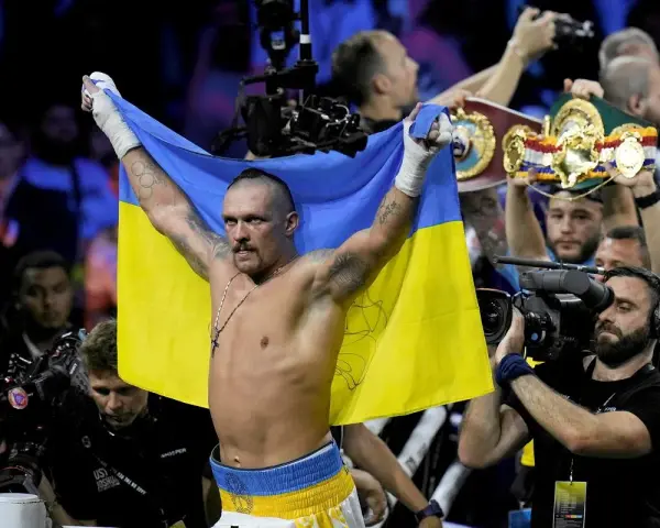 Oleksandr Usyk, po zwycięstwie nad Anthonym Joshuą, triumfalnie unosi flagę Ukrainy.