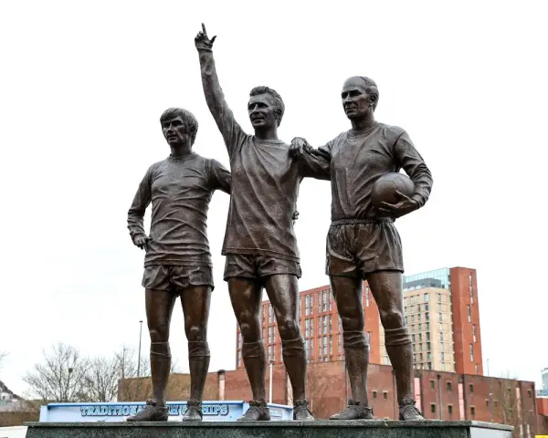 Pomnik trzech legend Manchesteru United: Charlton, Law i Best. Ich postacie upamiętniają złote lata klubu.