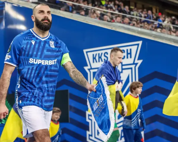 Piłkarz Lecha Poznań z flagą Szachtara na ręku, podczas meczu.