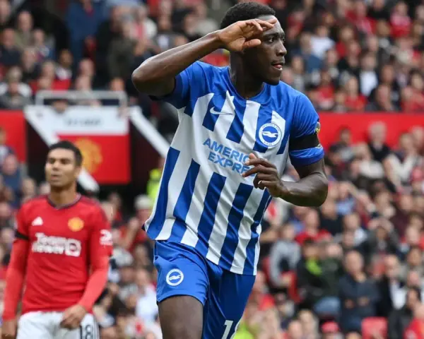Piłkarz Brighton w niebiesko-białej koszulce świętuje bramkę przeciwko Man Utd. Casemiro z Manchesteru United w tle.