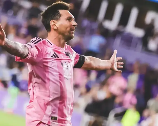 Leo Messi w różowej koszulce świętuje bramkę na stadionie, gdzie gra.