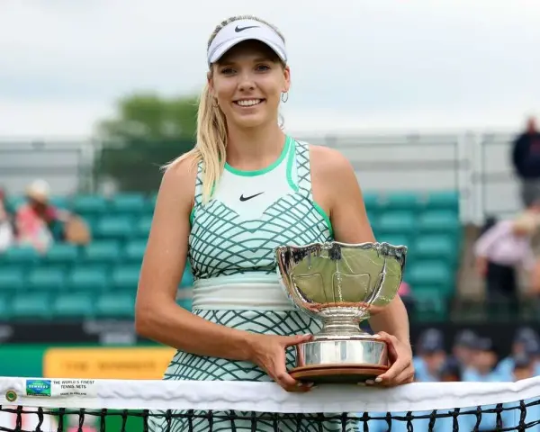 Katie Boulter z pucharem, uśmiechnięta na korcie tenisowym.