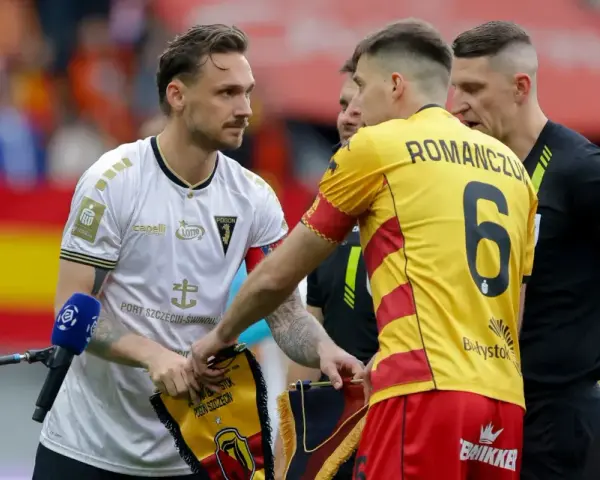 Piłkarze przed meczem Jagiellonia - Pogoń. Zawodnicy wymieniają się proporcami.
