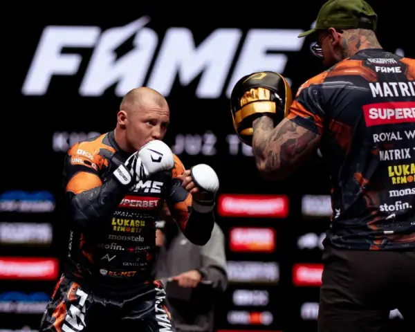 Bokserzy na treningu przed galą FAME MMA. Jeden z nich w rękawicach, drugi z łapami treningowymi.