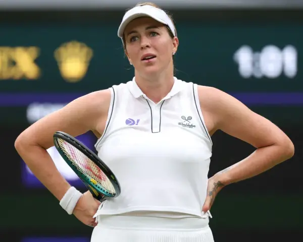 Anastasija Pawluczenkowa z rakietą, w białej koszulce Wimbledonu, zamyślona na korcie.