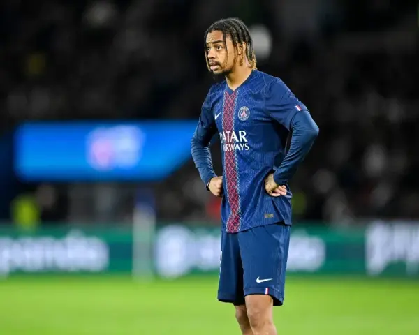 Piłkarz PSG w meczu z Le Havre AC, z rękami na biodrach, wpatrzony w dal.