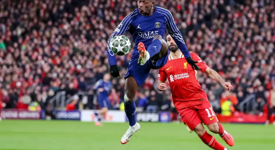 Piłkarz PSG w powietrzu z piłką, obok zawodnik Liverpoolu. Emocjonujący mecz PSG – Liverpool.