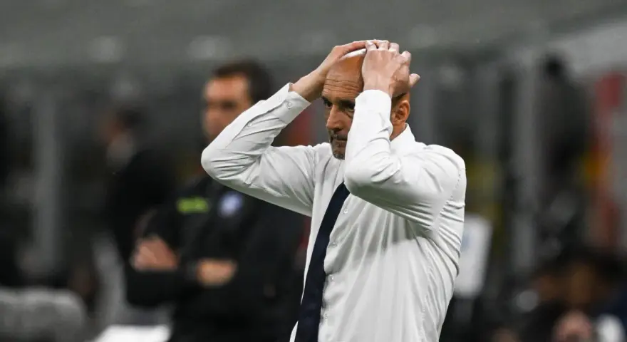 Trener w białej koszuli z granatowym krawatem, z rękami na głowie, przeżywa trudne chwile podczas meczu Juventus AC Milan.