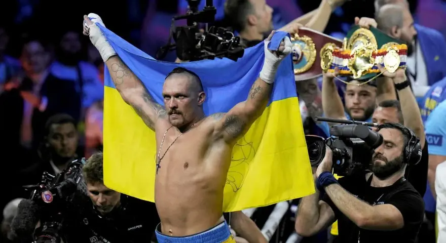 Oleksandr Usyk, po zwycięstwie nad Anthonym Joshuą, triumfalnie unosi flagę Ukrainy.