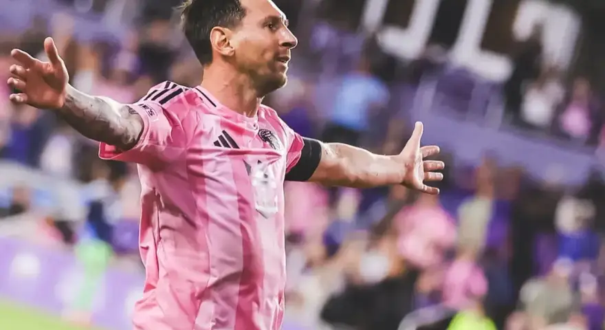 Leo Messi w różowej koszulce świętuje bramkę na stadionie, gdzie gra.