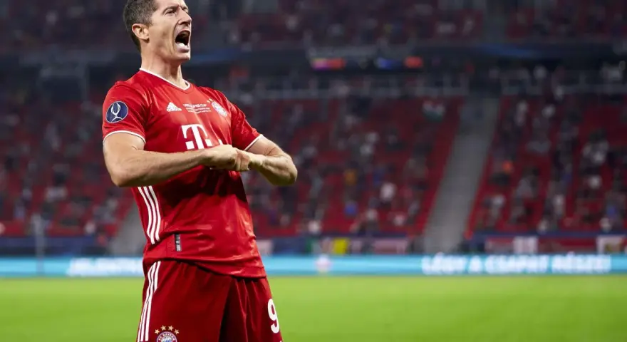 Robert Lewandowski w czerwonej koszulce Bayernu świętuje bramkę. Krótka biografia tego piłkarza to historia sukcesów.