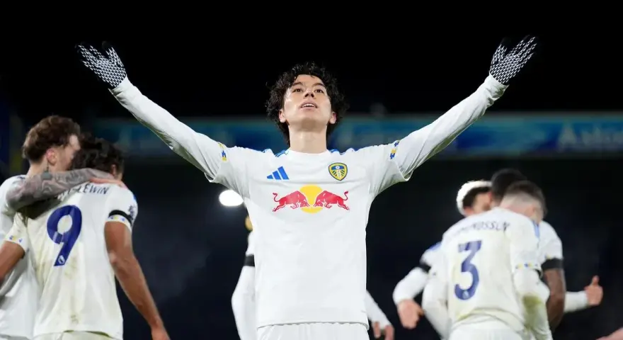 Piłkarz Leeds świętuje zwycięstwo nad Liverpoolem, wznosząc ręce ku górze.