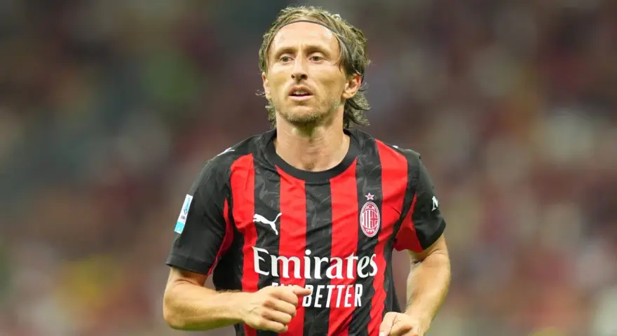 Piłkarz w czerwono-czarnej koszulce AC Milan, z opaską na głowie. Wciąż w świetnej formie, mimo że ile lat ma Luka Modrić, wciąż zachwyca.