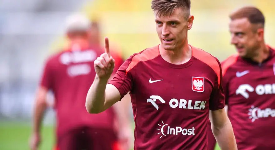 Krzysztof Piątek, w koszulce z orłem, pokazuje palcem do góry. Jego nowy krzysztof piątek transfer budzi nadzieję.