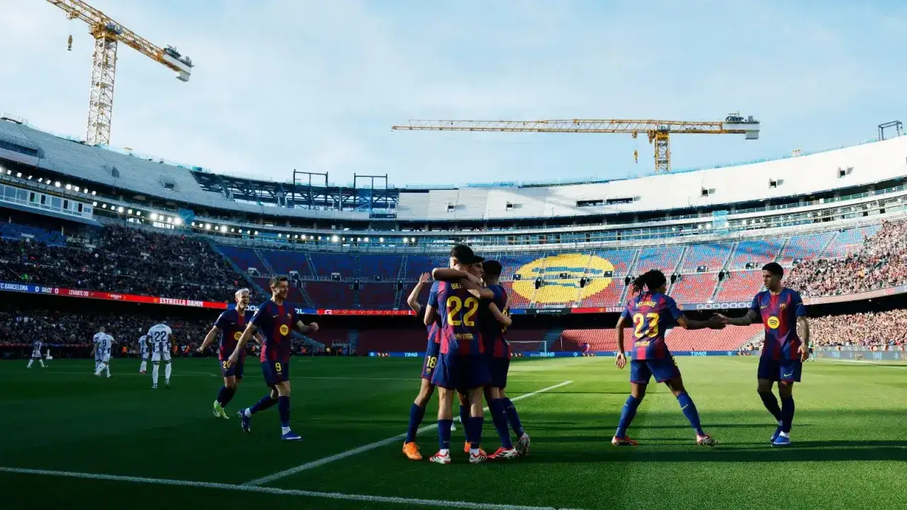 Piłkarze FC Barcelona świętują bramkę przeciwko Levante. Stadion Camp Nou, tłumy kibiców i dźwigi w tle.