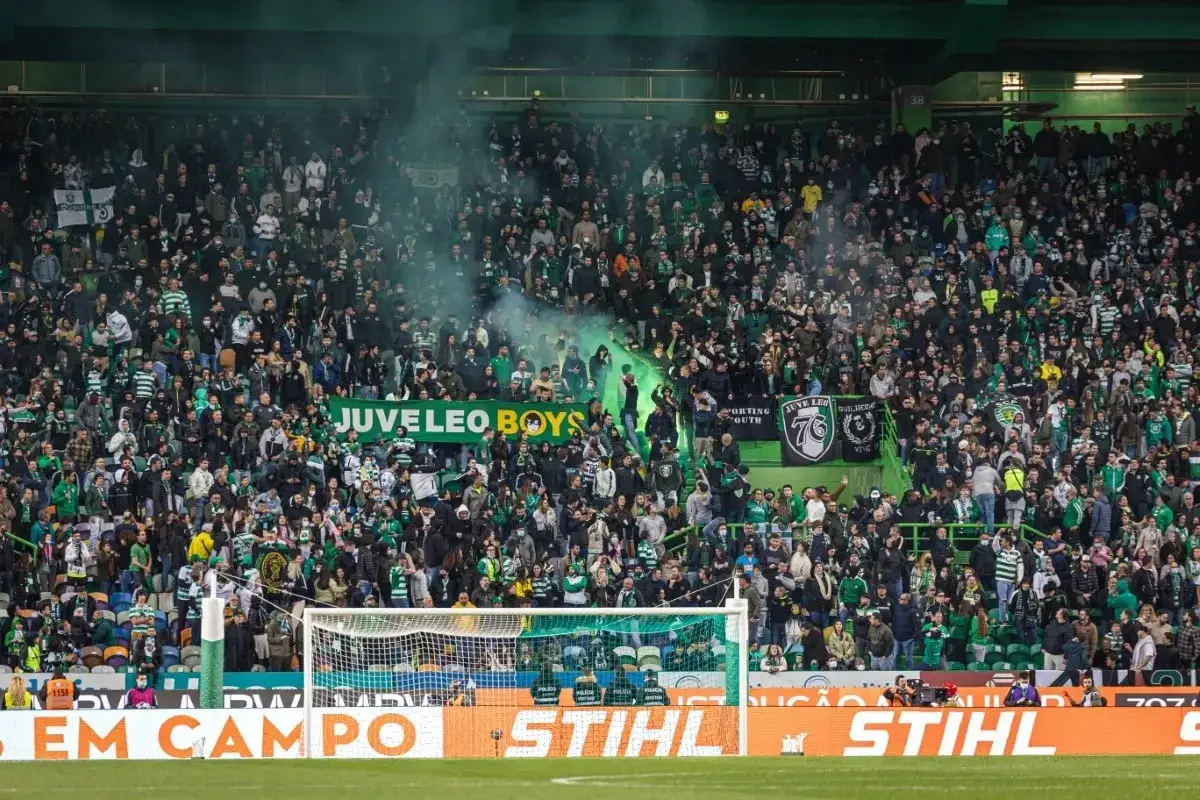 Tłum kibiców na stadionie podczas meczów Sporting Lizbona. Widać transparent