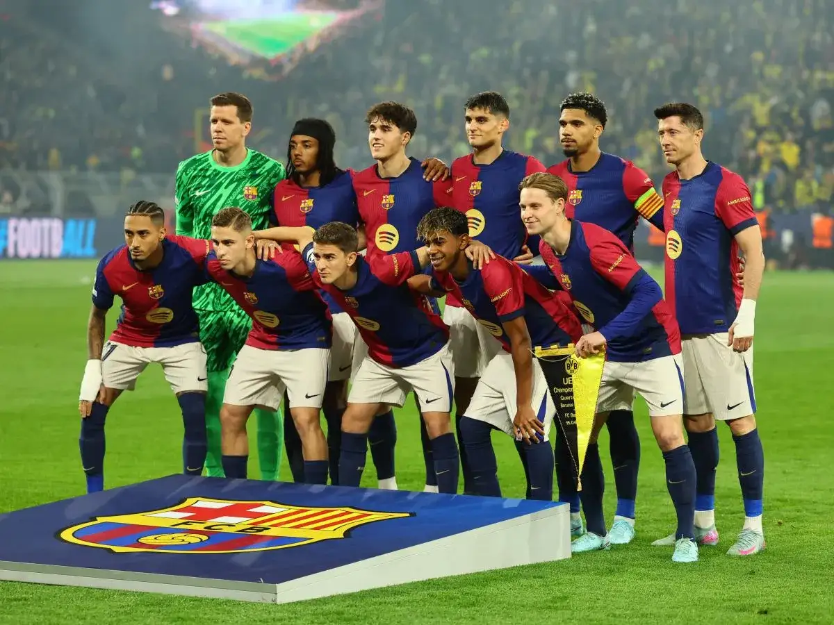 Drużyna FC Barcelona przed meczem z Celtą Vigo. Piłkarze w bordowo-granatowych strojach pozują do zdjęcia na tle trybun.