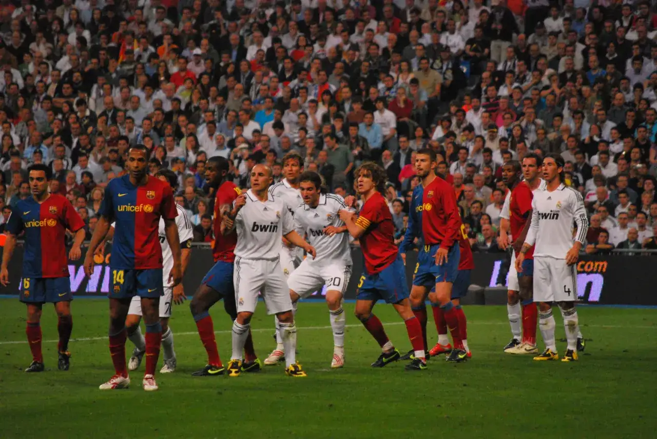 Piłkarze Realu Madryt i Barcelony w akcji. To fragment historii El Clasico, gdzie wyniki meczów budzą wielkie emocje.