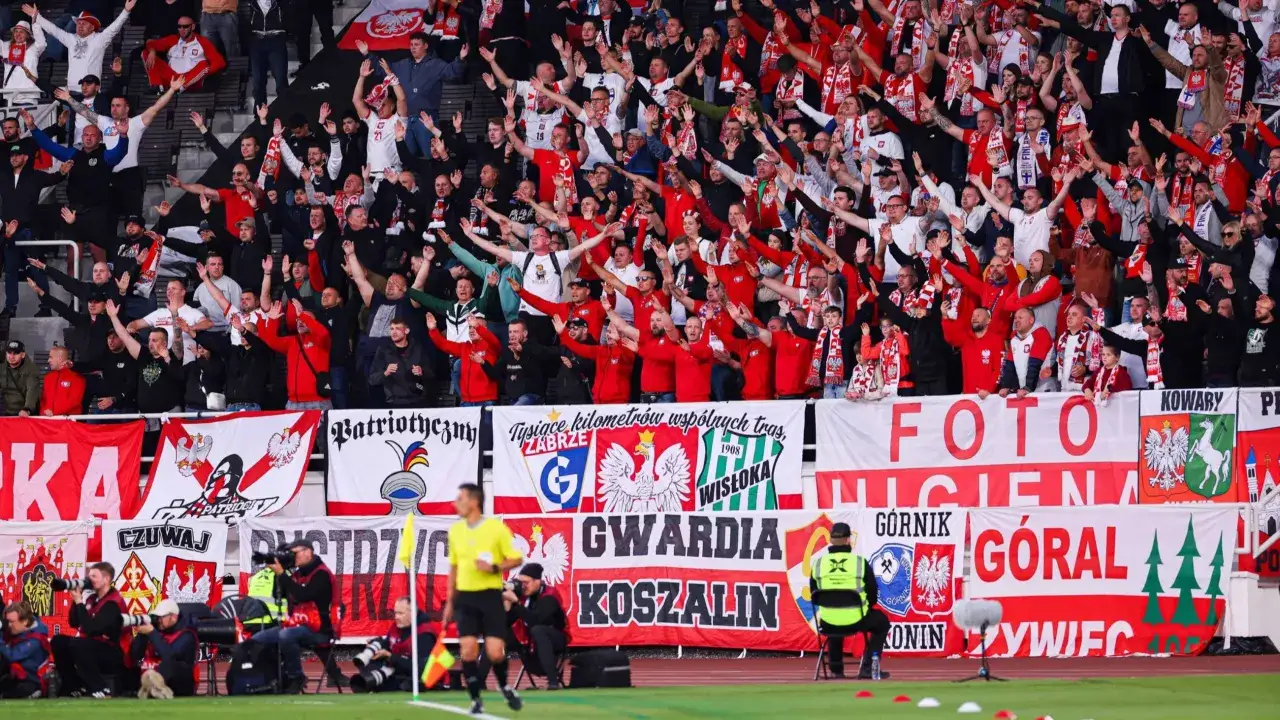 Tłum kibiców w biało-czerwonych barwach, z polskimi flagami i transparentami, dopingujący swoją drużynę. Emocje podczas meczu polska vs.