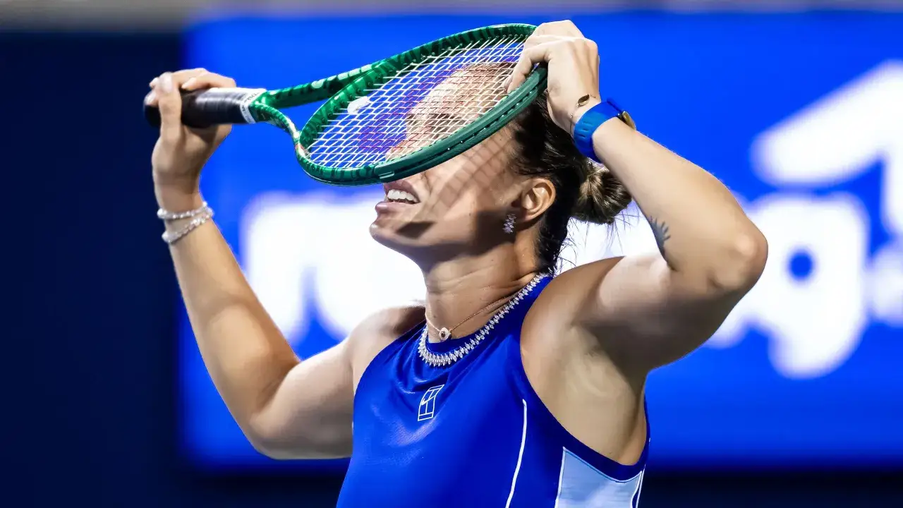 Aryna Sabalenka w emocjach po udanym zagraniu, trzyma rakietę nad głową.