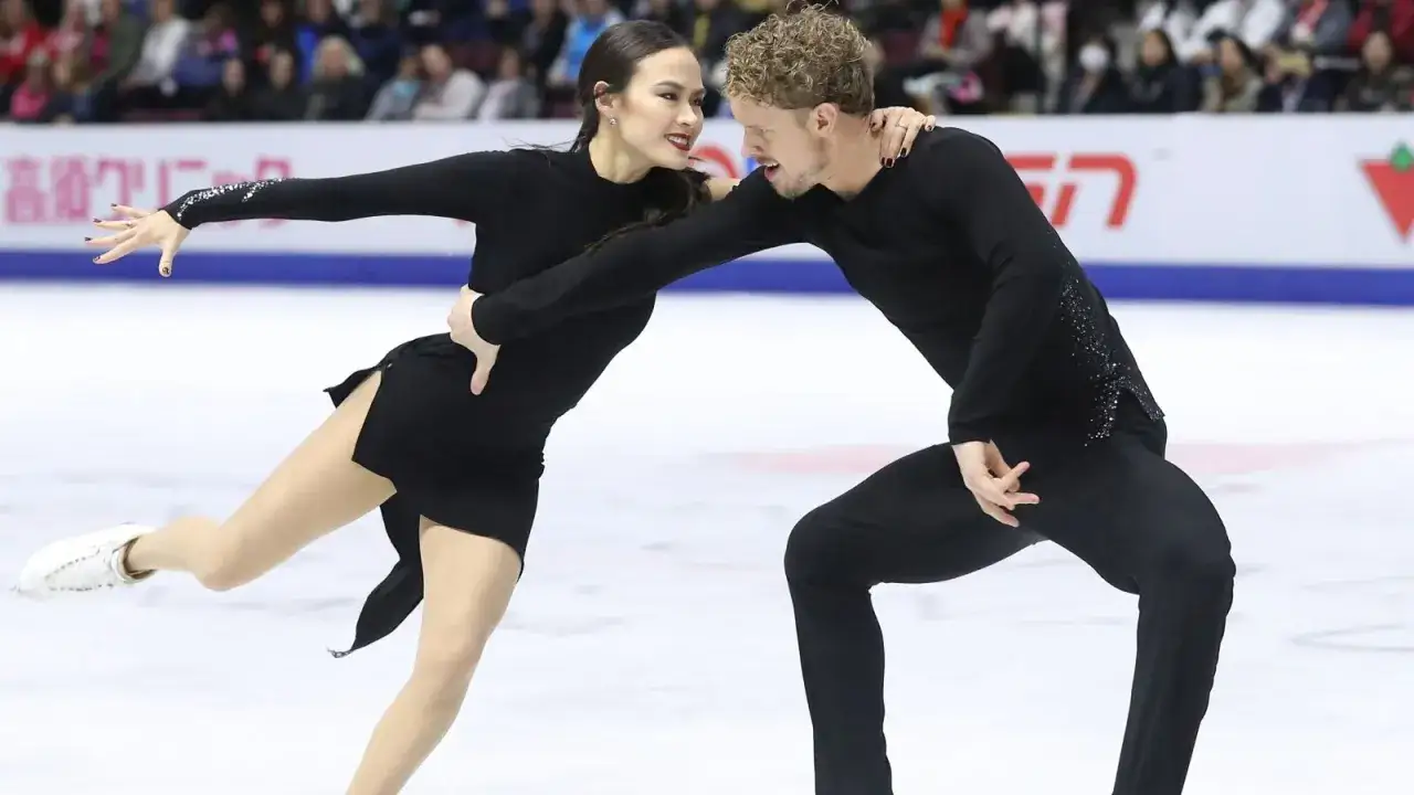 Para łyżwiarzy figurowych w czarnych strojach podczas zawodów Grand Prix.