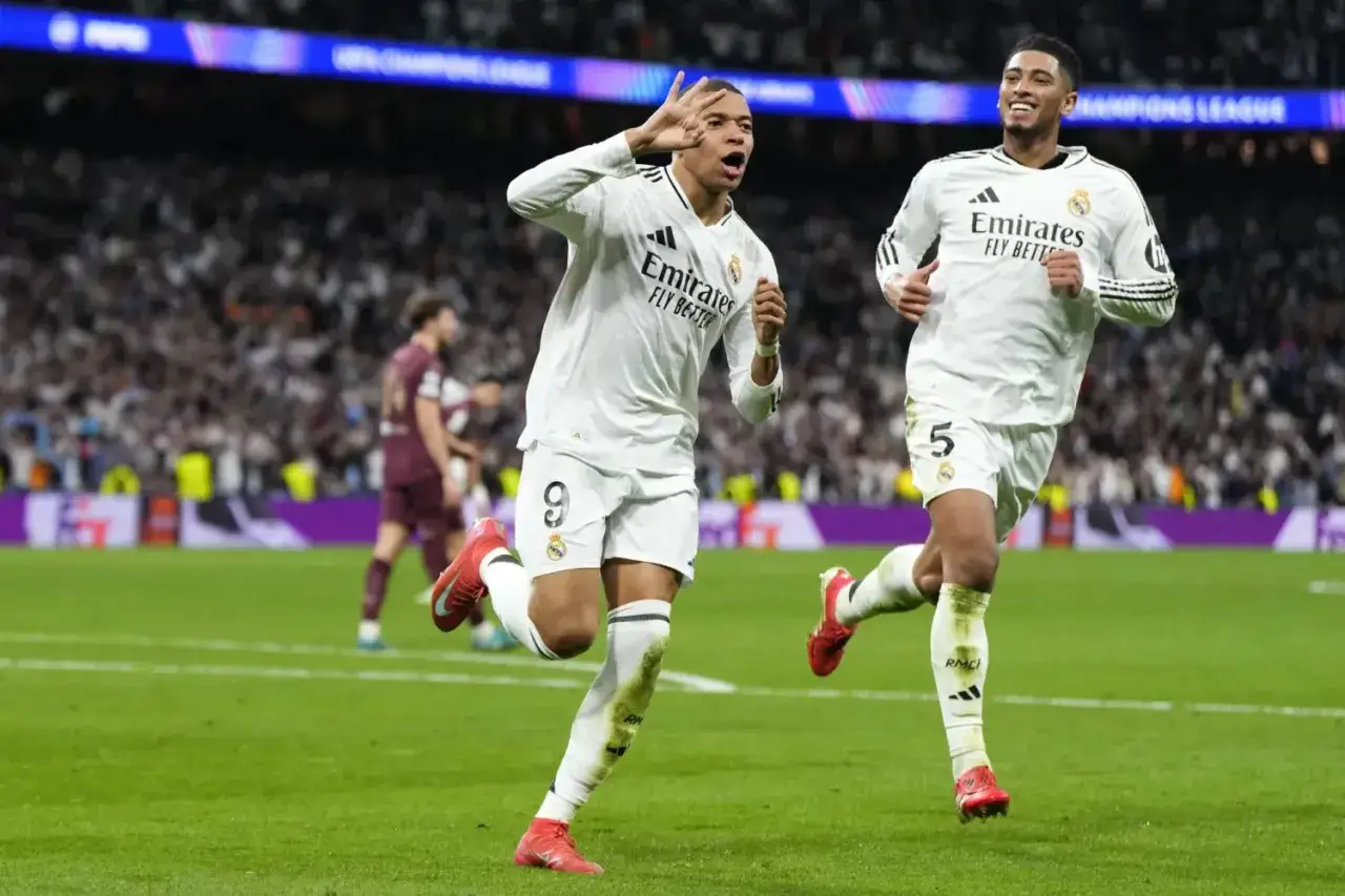 Kylian Mbappé w białej koszulce Realu Madryt świętuje bramkę, biegnąc po zielonej murawie stadionu.