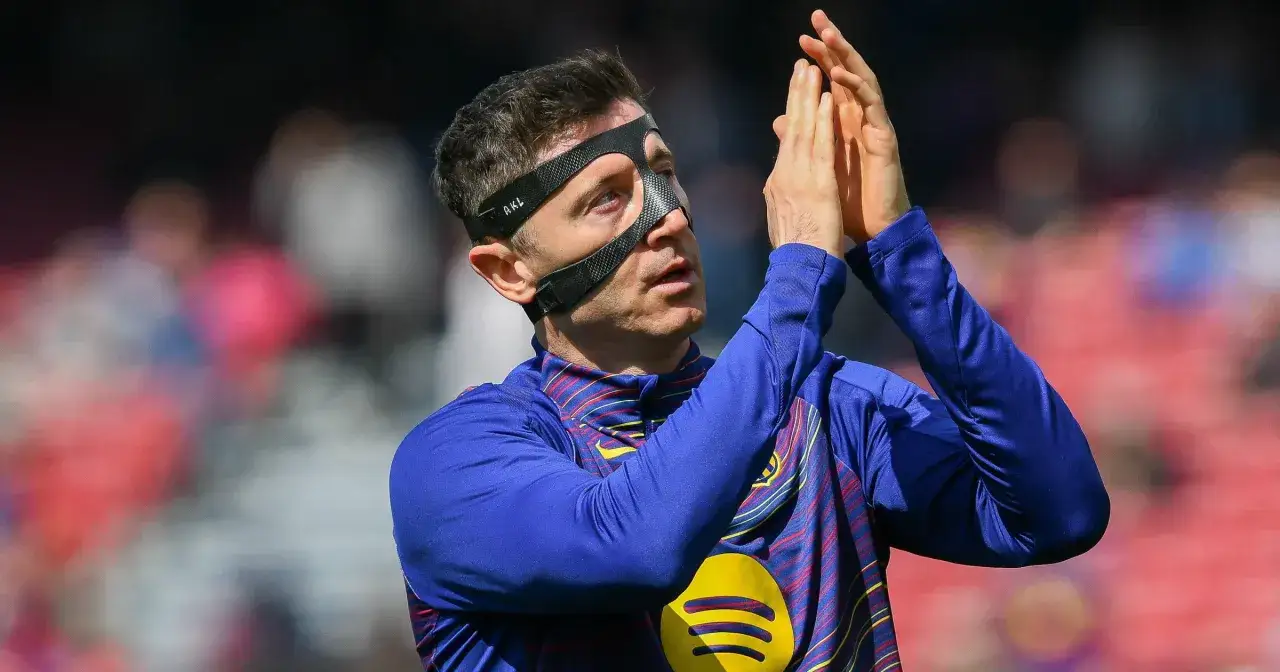 Robert Lewandowski w masce, z dłońmi złożonymi do oklasków. Kibice zastanawiają się, ile zarabia Lewandowski w Barcelonie.