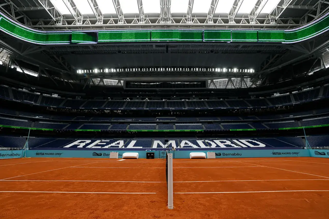 Pusta ceglana kort tenisowy na stadionie Santiago Bernabéu, gotowy na turniej tenisowy w Madrycie.