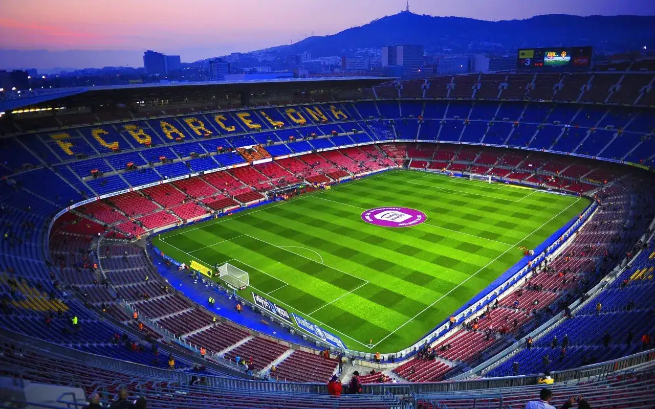 Camp Nou przed meczami Barcelony 2025. Stadion w barwach klubowych, z widokiem na miasto i wzgórza.