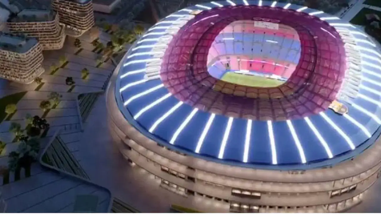 Nowe Camp Nou w nocnej odsłonie, z oświetlonym dachem i otaczającymi budynkami.