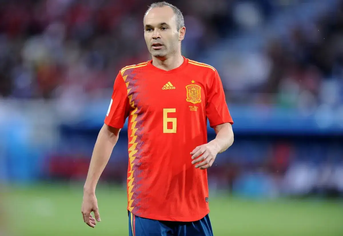 Andrés Iniesta w czerwonej koszulce z numerem 6, symbolizuje reprezentację Hiszpanii w piłce nożnej mężczyzn.