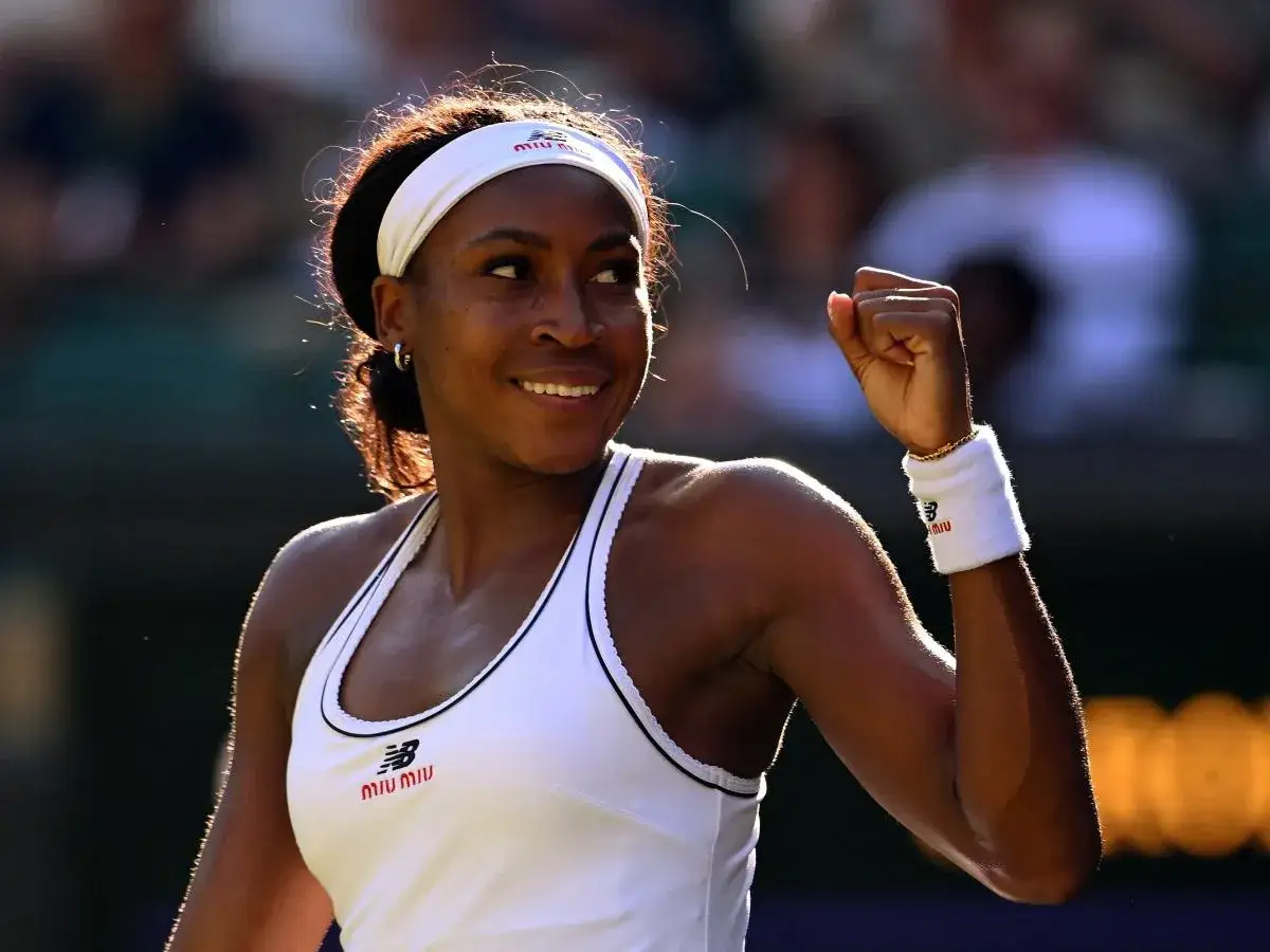 Uśmiechnięta Coco Gauff, kiedy gra, unosi zaciśniętą pięść w geście triumfu.