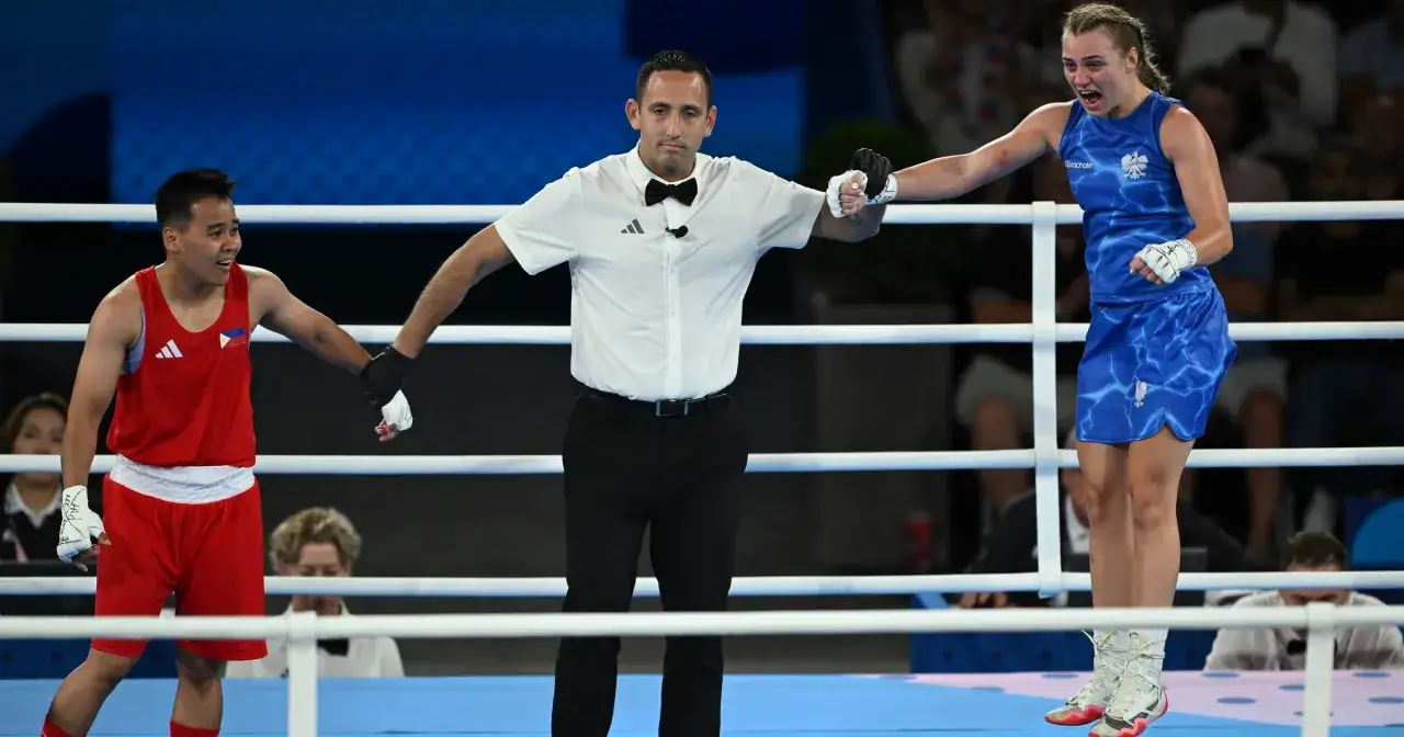 Julia Szeremeta triumfuje w bokserskim ringu, sędzia ogłasza zwycięstwo.