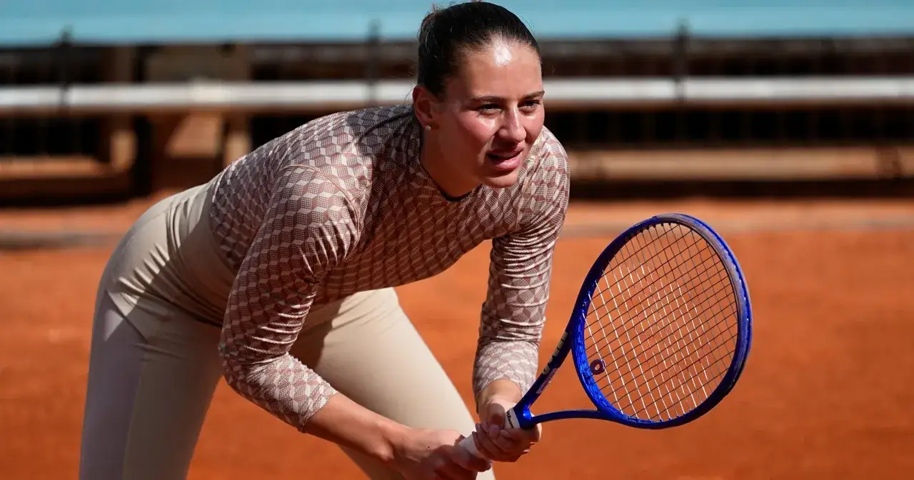 Marta Kostiuk w skupieniu czeka na return na ceglanym korcie, gotowa do kolejnego uderzenia.