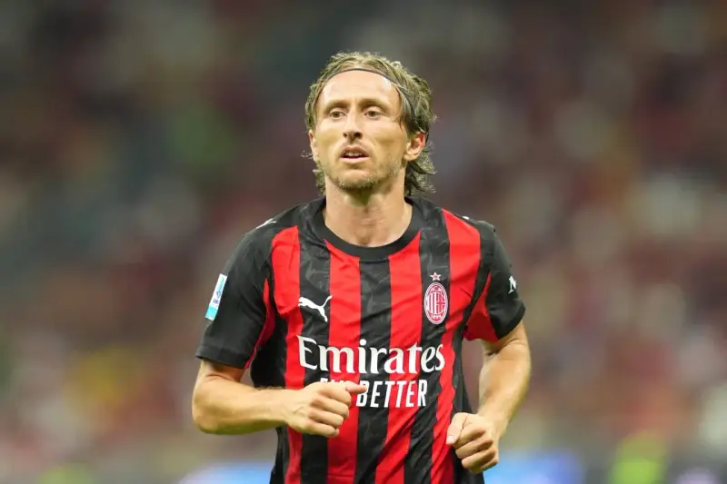 Piłkarz w czerwono-czarnej koszulce AC Milan, z opaską na głowie. Wciąż w świetnej formie, mimo że ile lat ma Luka Modrić, wciąż zachwyca.